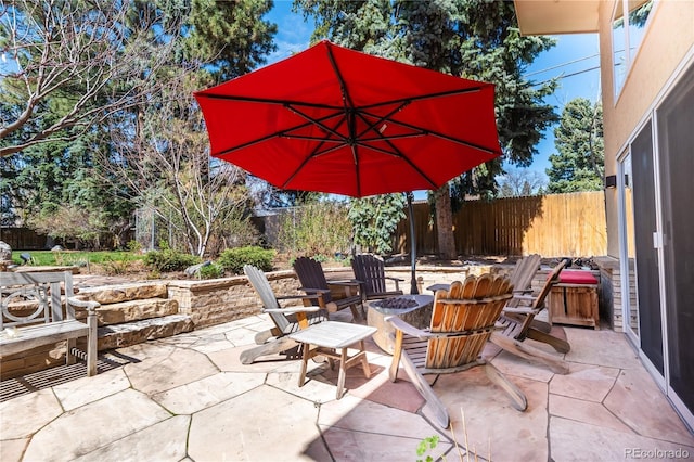 view of patio featuring a fenced backyard and a fire pit