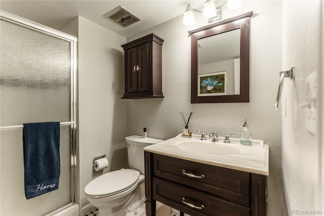 bathroom featuring a shower stall, toilet, vanity, and visible vents