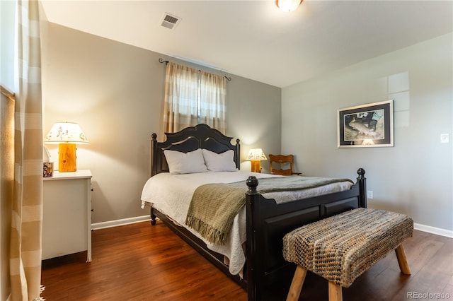 bedroom with baseboards, wood finished floors, and visible vents