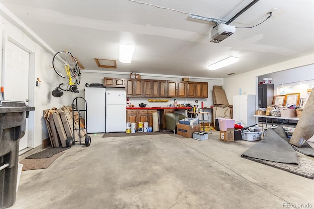 garage featuring freestanding refrigerator, a garage door opener, a workshop area, and refrigerator