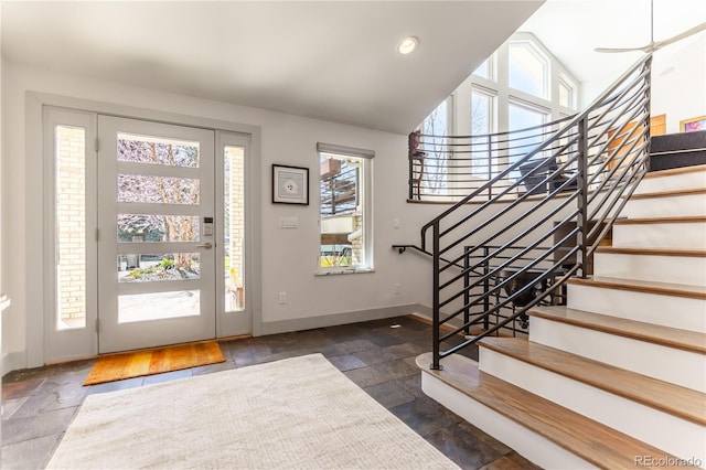 foyer with stone tile floors, baseboards, recessed lighting, and stairway