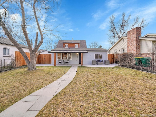 rear view of house with a patio, a lawn, and a fenced backyard