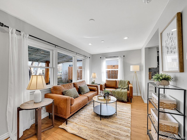 living room featuring light wood-style floors, baseboards, and recessed lighting