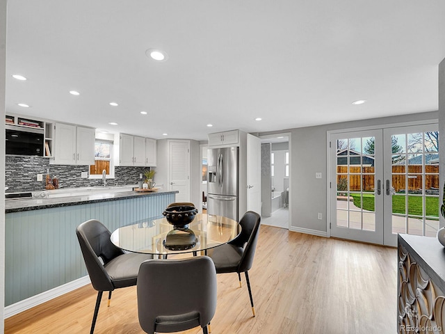 dining area featuring recessed lighting, light wood finished floors, plenty of natural light, and french doors