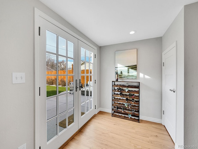 entryway featuring french doors, light wood-type flooring, recessed lighting, and baseboards