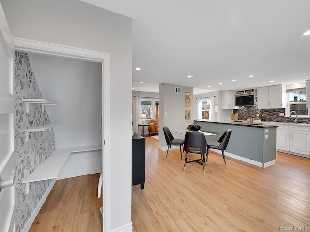 interior space with recessed lighting, visible vents, light wood-style flooring, and baseboards