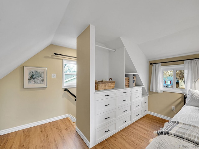 bedroom featuring light wood-style floors, vaulted ceiling, and baseboards