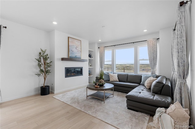 13446 Amber Sky St, Parker, CO 80134 - living room featuring wood finished floors, a glass covered fireplace, recessed lighting, and baseboards