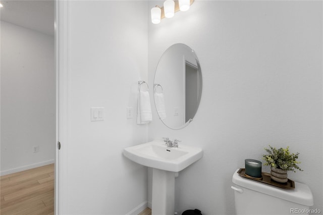 13446 Amber Sky St, Parker, CO 80134 - half bathroom with wood finished floors, toilet, baseboards, and a sink