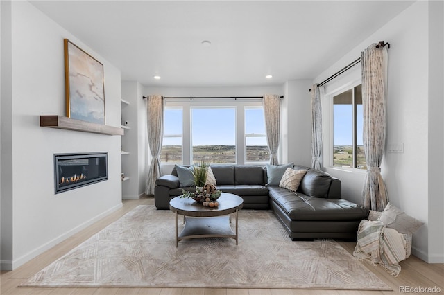 13446 Amber Sky St, Parker, CO 80134 - living room featuring a glass covered fireplace, baseboards, recessed lighting, and wood finished floors