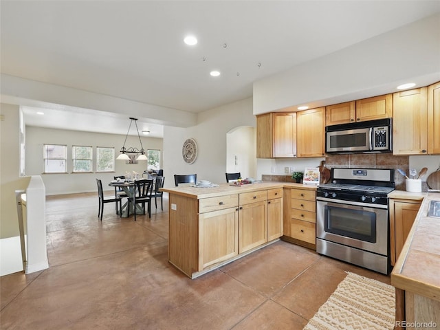 kitchen featuring stainless steel appliances, finished concrete flooring, arched walkways, light brown cabinets, and recessed lighting