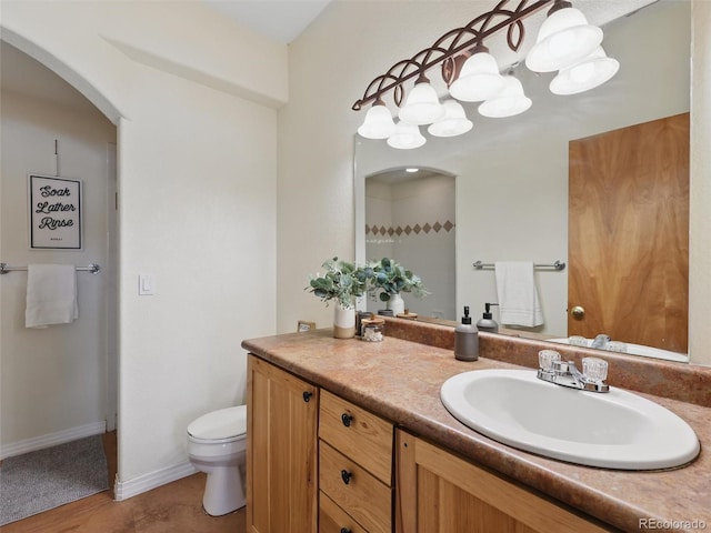 bathroom featuring vanity, toilet, and baseboards