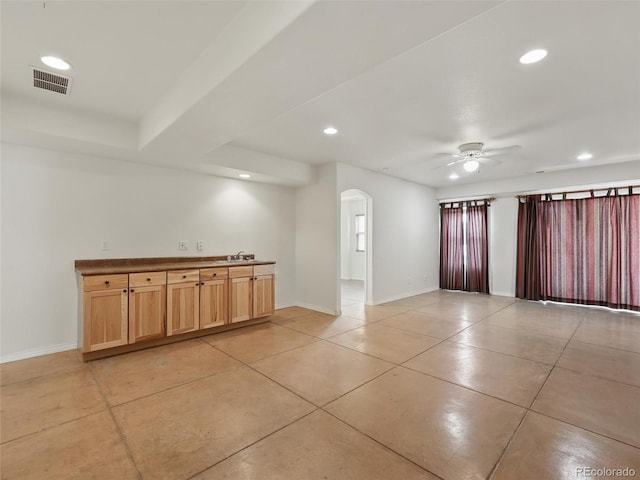 empty room with arched walkways, light tile patterned flooring, a ceiling fan, baseboards, and recessed lighting