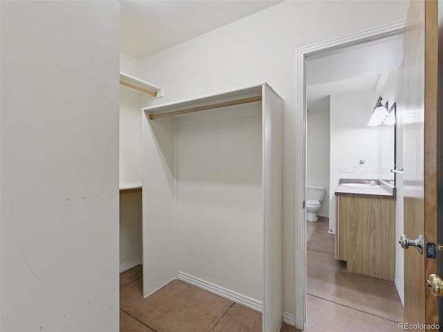spacious closet with light tile patterned floors