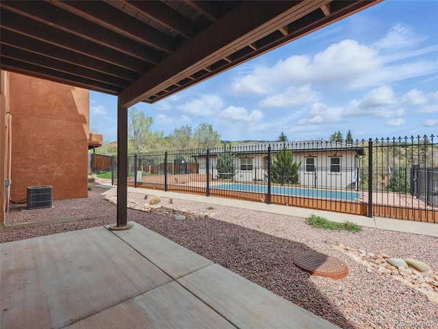 view of patio / terrace featuring fence, central AC unit, and a community pool