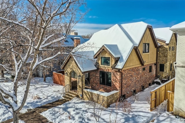 view of front of home with brick siding and a chimney