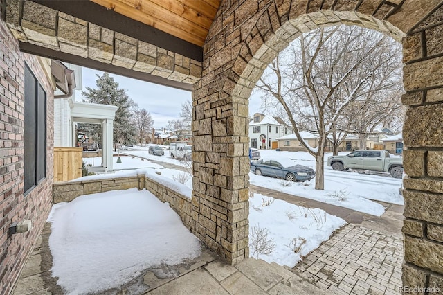 snow covered patio with a residential view