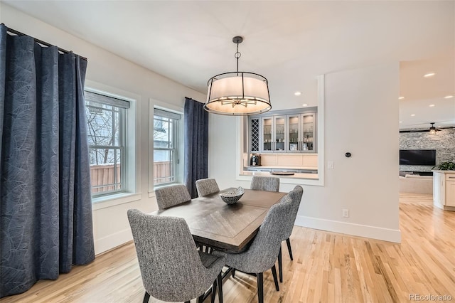 dining space with light wood-style flooring, baseboards, and recessed lighting