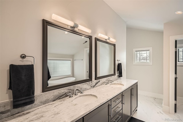 bathroom featuring marble finish floor, a sink, baseboards, and double vanity