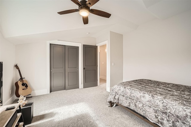 carpeted bedroom featuring a ceiling fan, lofted ceiling, a closet, and baseboards