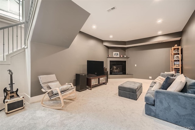 living room featuring a glass covered fireplace, carpet flooring, visible vents, and recessed lighting