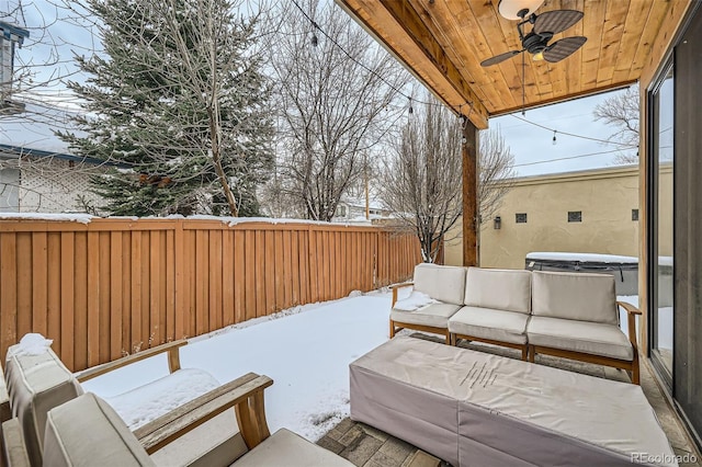 yard layered in snow with ceiling fan, an outdoor living space, and fence