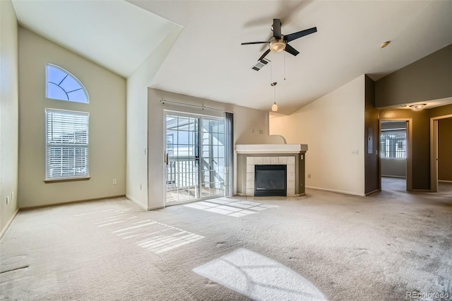 living room featuring a tile fireplace, high vaulted ceiling, light colored carpet, and ceiling fan