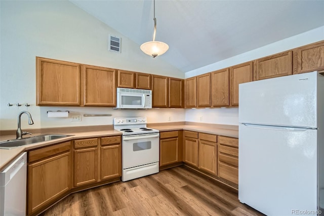 kitchen with hardwood / wood-style floors, pendant lighting, lofted ceiling, sink, and white appliances