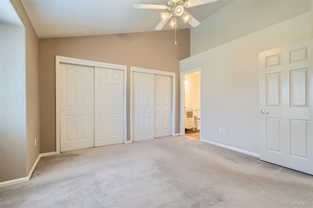 unfurnished bedroom with multiple closets, lofted ceiling, light carpet, and ceiling fan