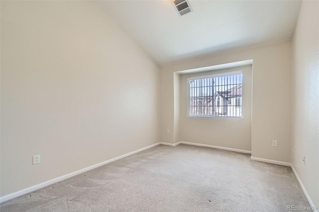 carpeted spare room featuring lofted ceiling