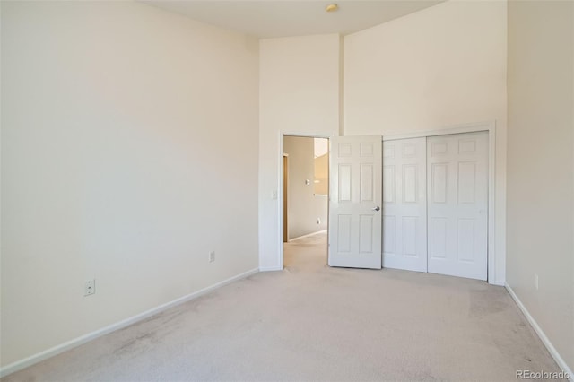 unfurnished bedroom featuring a closet and light carpet