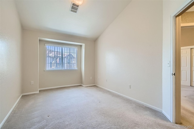 carpeted empty room with lofted ceiling