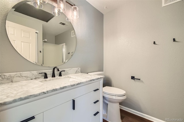 bathroom with vanity, wood-type flooring, and toilet