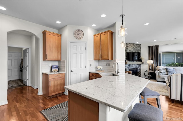 10152 Bluffmont Ln, Lone Tree, CO 80124 - kitchen with a peninsula, arched walkways, open floor plan, decorative backsplash, and recessed lighting