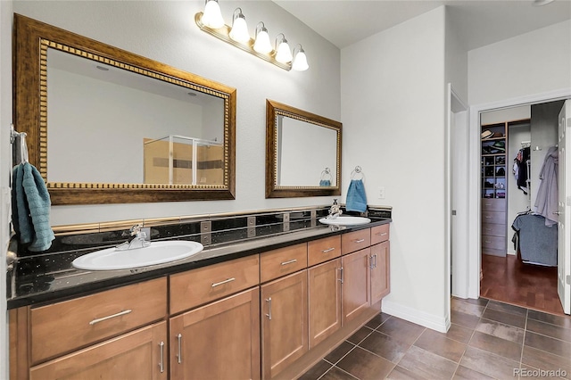 10152 Bluffmont Ln, Lone Tree, CO 80124 - full bath featuring double vanity, a spacious closet, a stall shower, and tile patterned floors