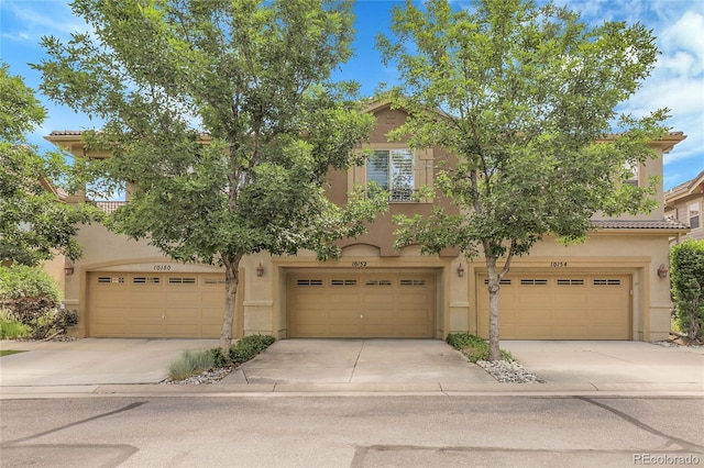 10152 Bluffmont Ln, Lone Tree, CO 80124 - view of front of property with stucco siding, a garage, concrete driveway, and a tiled roof