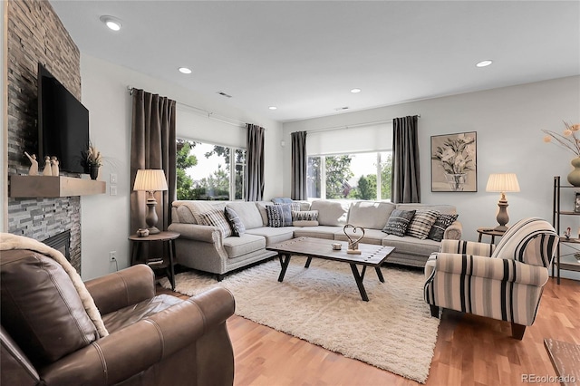 10152 Bluffmont Ln, Lone Tree, CO 80124 - living area featuring a stone fireplace, healthy amount of natural light, wood finished floors, and recessed lighting