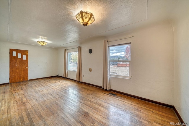 empty room featuring hardwood / wood-style floors and a textured ceiling