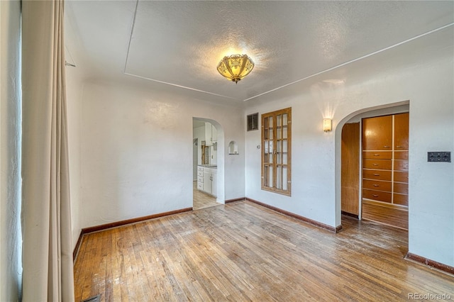 spare room with hardwood / wood-style floors and a textured ceiling