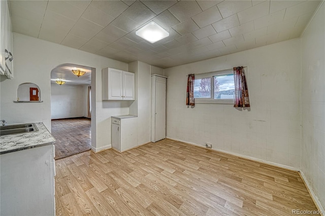 kitchen featuring sink, light wood-type flooring, and white cabinets