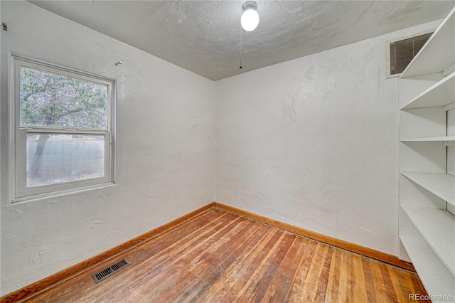 spare room with hardwood / wood-style floors and a textured ceiling