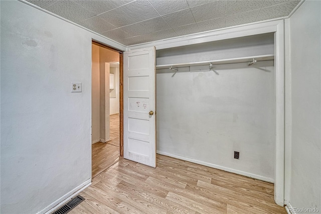 unfurnished bedroom featuring a closet and light hardwood / wood-style floors