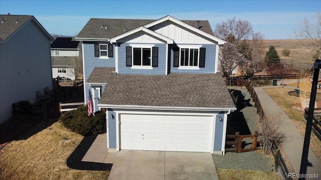 view of front of home with roof with shingles, board and batten siding, an attached garage, and fence