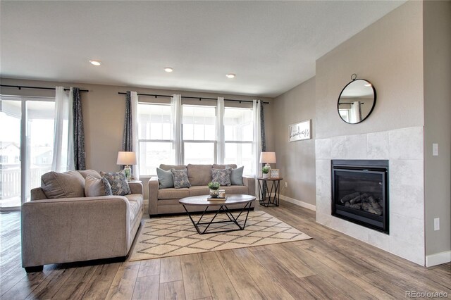 4090 Forever Cir, Castle Rock, CO 80109 - living room with wood finished floors, healthy amount of natural light, baseboards, a tile fireplace, and recessed lighting