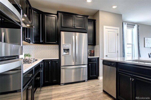4090 Forever Cir, Castle Rock, CO 80109 - kitchen with stainless steel appliances, dark cabinetry, backsplash, and recessed lighting