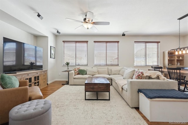 living room featuring ceiling fan and light wood-type flooring