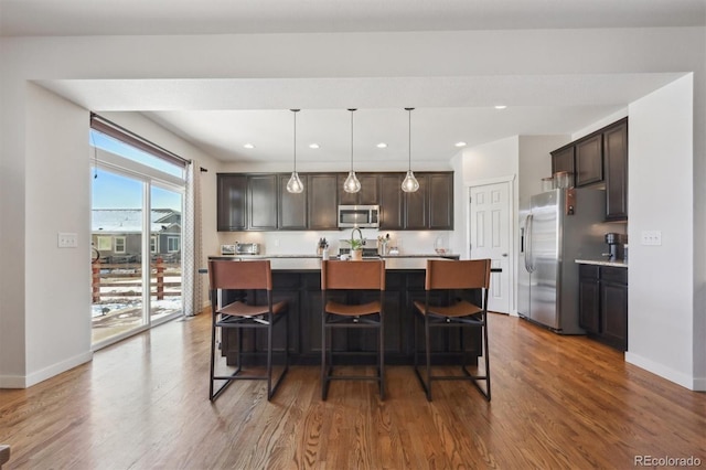 kitchen featuring dark brown cabinets, an island with sink, and appliances with stainless steel finishes