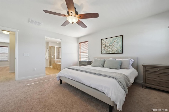 carpeted bedroom with multiple windows, ensuite bathroom, and ceiling fan