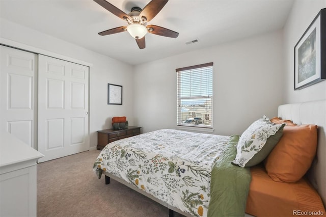 bedroom featuring ceiling fan, light colored carpet, and a closet