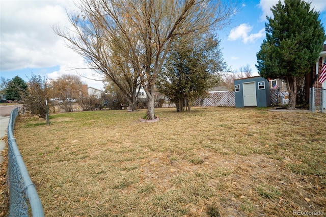 view of yard with an outbuilding, a shed, and fence